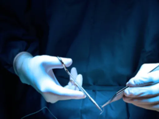 Gloved hands in operating room