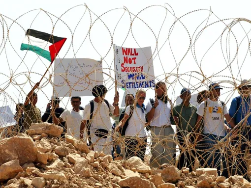 Palestinian and activists from the International Solidarity Movement (ISM) protest against Israel's security fence on August 15, 2003 at the West Bank Palestinian village of Khirbet Ras Atira. (David Silverman/Getty Images)