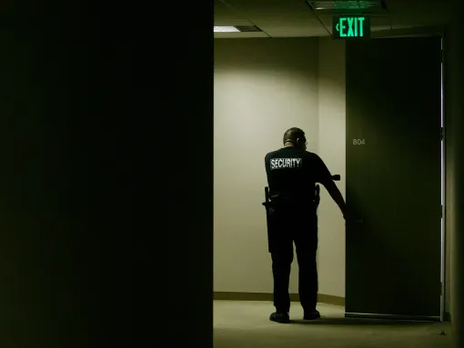 Security Guard with Flashlight Checking Doorway
